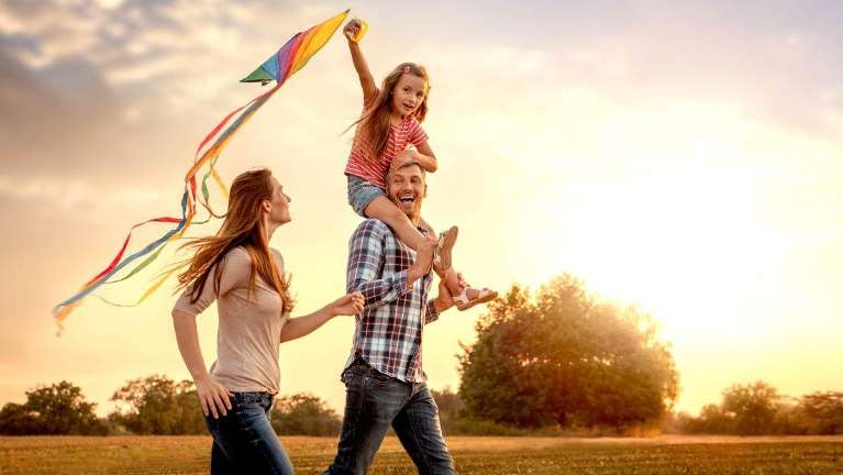 young family playing in the park at maple grove