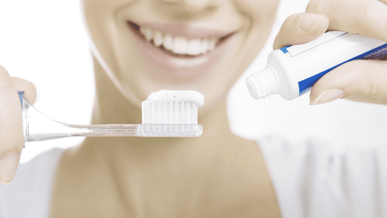 woman brushing her teeth in maple grove mn