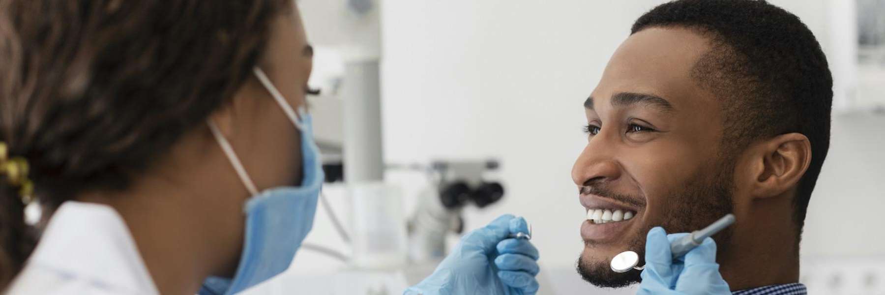 smiling man during a dental exam in maple grove